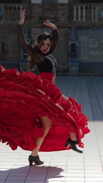 Flamenco dancer twirls in front of grand building backdrop. Overlaid is the Spanish word "bailar" with its English translation, "to dance".